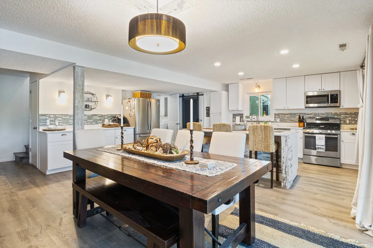 A spacious, inviting dining area featuring a dining table, a kitchen island, and a stylish light fixture overhead. The setup emphasizes togetherness and is suitable for both family meals and festive gatherings.